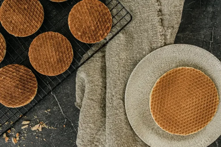 Klassieke stroopwafel op een bord, met meer stroopwafels op een rooster